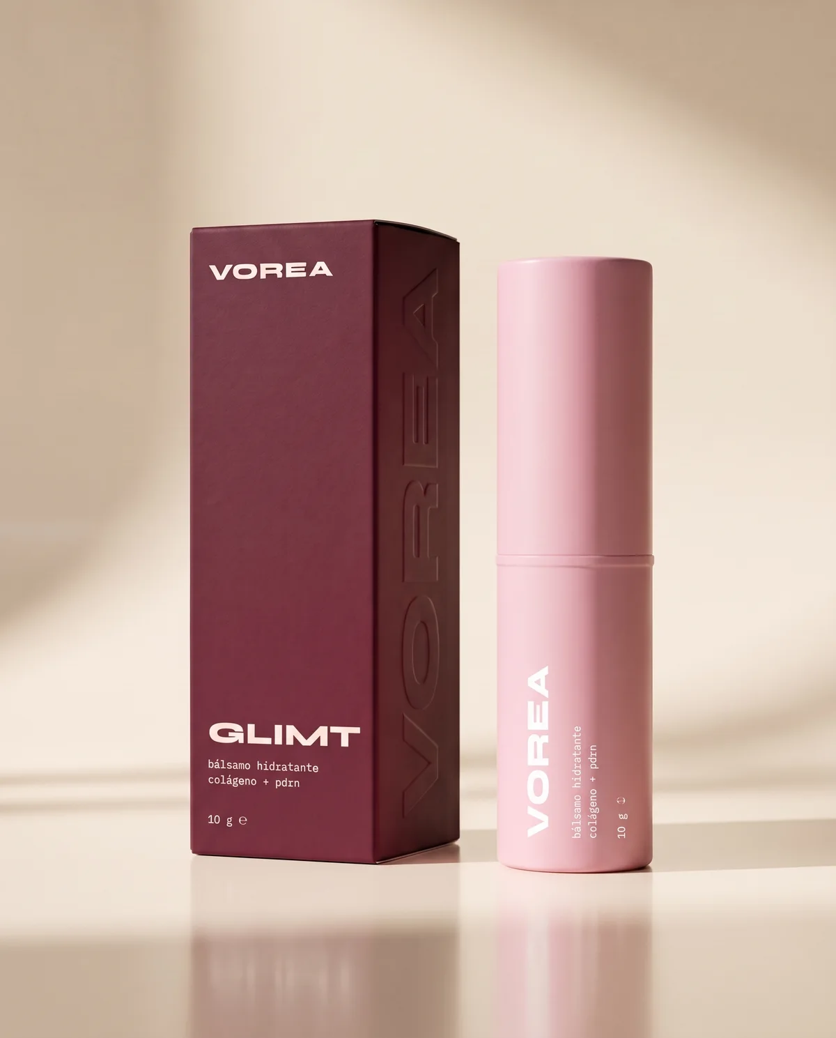Caja burdeos de VOREA Glimt junto al stick rosa